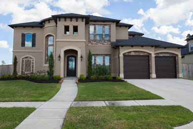 Large tuscan brown two-story stucco exterior home photo in Houston
