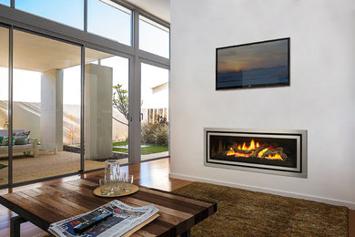 Photo of a large modern open concept living room in Melbourne with white walls, medium hardwood floors, a ribbon fireplace, a metal fireplace surround and a wall-mounted tv.
