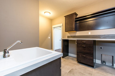 Large transitional galley ceramic tile and gray floor dedicated laundry room photo in Seattle with shaker cabinets, dark wood cabinets, laminate countertops and gray walls