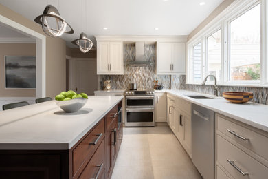Large transitional porcelain tile eat-in kitchen photo in Boston with a single-bowl sink, quartz countertops, multicolored backsplash, glass tile backsplash, stainless steel appliances, an island and white countertops
