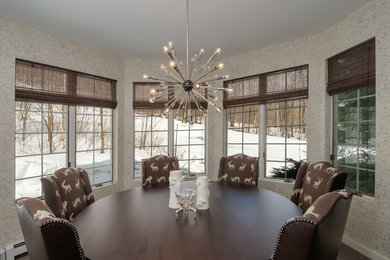 Example of a mid-sized trendy carpeted and brown floor enclosed dining room design in Burlington with white walls