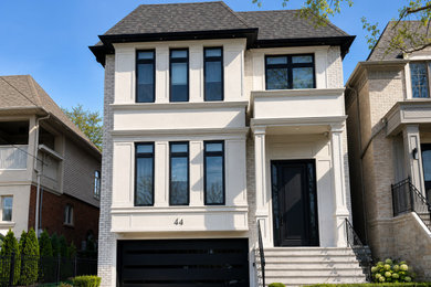 Example of a mid-sized trendy white two-story stucco exterior home design in Toronto with a shingle roof and a black roof