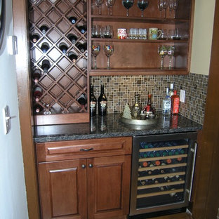 タンパの小さいトラディショナルスタイルのおしゃれなウェットバー (シンクなし、中間色木目調キャビネット、御影石カウンター、茶色いキッチンパネル、磁器タイルのキッチンパネル、無垢フローリング、茶色い床、落し込みパネル扉のキャビネット) の写真