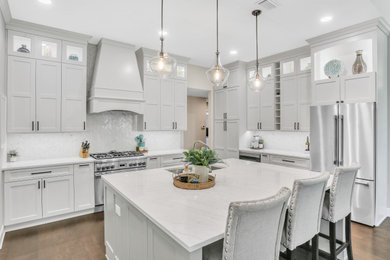 Design ideas for a transitional kitchen in Jacksonville with an undermount sink, flat-panel cabinets, white cabinets, quartz benchtops, white splashback, marble splashback, stainless steel appliances, dark hardwood floors, with island, brown floor and white benchtop.