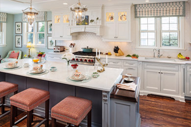 Kitchen - traditional dark wood floor and brown floor kitchen idea in Milwaukee with an undermount sink, recessed-panel cabinets, white cabinets, white backsplash, stainless steel appliances, an island and white countertops