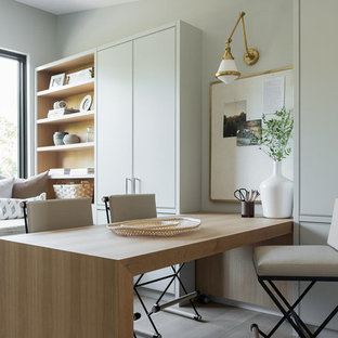 Inspiration for a medium sized modern craft room in Salt Lake City with grey walls, light hardwood flooring, no fireplace, a built-in desk and brown floors.