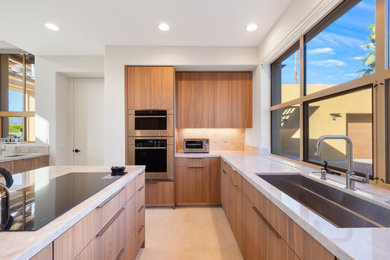 Minimalist galley ceramic tile and beige floor enclosed kitchen photo in Other with a farmhouse sink, flat-panel cabinets, medium tone wood cabinets, marble countertops, beige backsplash, porcelain backsplash, stainless steel appliances, an island and white countertops