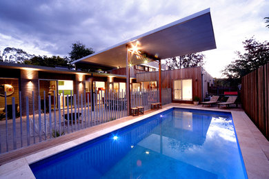 Photo of a large contemporary two-storey exterior in Canberra - Queanbeyan with wood siding and a flat roof.