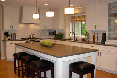 Design ideas for a mid-sized transitional u-shaped eat-in kitchen in Grand Rapids with recessed-panel cabinets, white cabinets and with island.