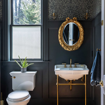 Powder room with period wallpaper and brass console sink