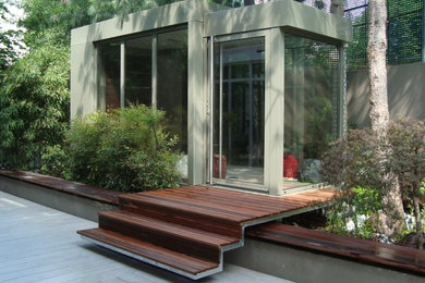Exemple d'une véranda tendance de taille moyenne avec un sol en bois brun, un plafond standard et un sol marron.