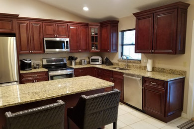 Inspiration for a mid-sized timeless l-shaped ceramic tile and white floor open concept kitchen remodel in Tampa with an undermount sink, raised-panel cabinets, dark wood cabinets, granite countertops, beige backsplash, stainless steel appliances and an island