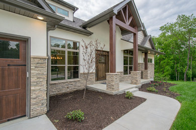 Inspiration for a large rustic beige one-story stucco exterior home remodel in Other with a shingle roof