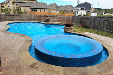 Example of a mid-sized tuscan backyard stone and custom-shaped natural hot tub design in Houston