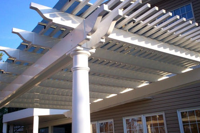 Example of a classic backyard patio design in St Louis with decking and a pergola