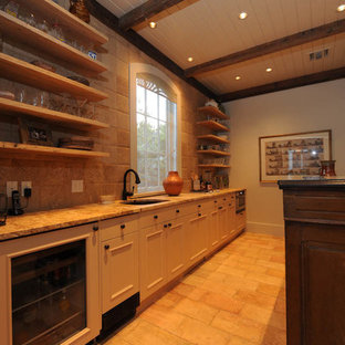 ニューオリンズの中サイズのラスティックスタイルのおしゃれなウェットバー (アンダーカウンターシンク、オープンシェルフ、淡色木目調キャビネット、御影石カウンター、ベージュキッチンパネル、テラコッタタイルのキッチンパネル、テラコッタタイルの床) の写真