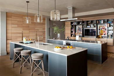 Inspiration for a huge contemporary u-shaped medium tone wood floor eat-in kitchen remodel in Austin with an undermount sink, paneled appliances, two islands, flat-panel cabinets, light wood cabinets and marble countertops
