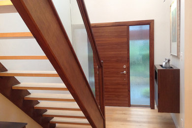 Inspiration for a mid-sized contemporary light wood floor entryway remodel in Vancouver with white walls and a medium wood front door