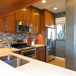 Inspiration for a medium sized modern l-shaped open plan kitchen in Los Angeles with a double-bowl sink, shaker cabinets, medium wood cabinets, engineered stone countertops, blue splashback, glass tiled splashback, stainless steel appliances, travertine flooring, no island, beige floors and yellow worktops.