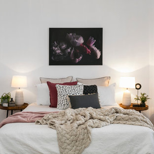 Contemporary bedroom in Hobart with white walls and medium hardwood floors.