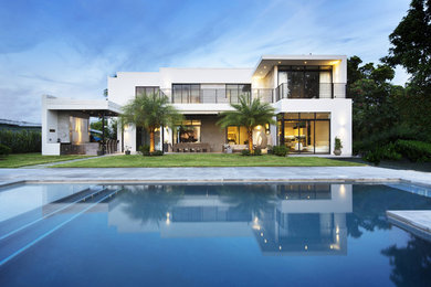 Contemporary two-storey white house exterior in Miami with a flat roof.