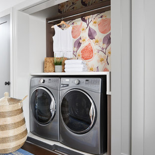 トロントの小さいトランジショナルスタイルのおしゃれなランドリークローゼット (シェーカースタイル扉のキャビネット、人工大理石カウンター、左右配置の洗濯機・乾燥機、グレーのキャビネット、白い壁、濃色無垢フローリング、茶色い床、白いキッチンカウンター) の写真
