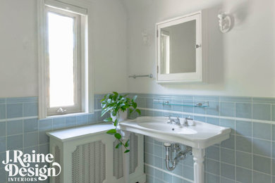 Example of a mid-sized classic master blue tile and ceramic tile porcelain tile and single-sink alcove shower design in Detroit with a two-piece toilet, white walls, a console sink, a hinged shower door and a niche