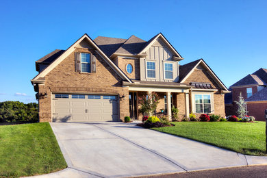 Large elegant brown two-story brick exterior home photo in Other