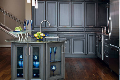 Mid-sized minimalist l-shaped medium tone wood floor and brown floor eat-in kitchen photo in Dallas with an undermount sink, raised-panel cabinets, gray cabinets, granite countertops, stainless steel appliances, an island and multicolored countertops