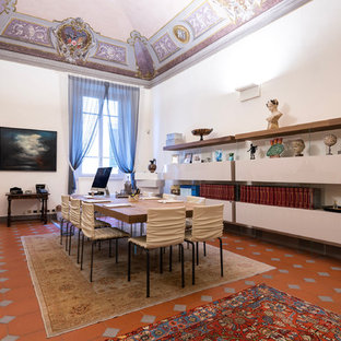 Design ideas for a large modern study in Florence with white walls, terracotta flooring, a standard fireplace, a concrete fireplace surround, a freestanding desk and brown floors.