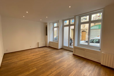 Ejemplo de sala de estar abierta moderna de tamaño medio con paredes blancas, suelo vinílico y suelo marrón