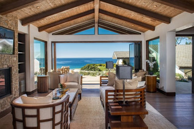 Inspiration for a large beach style open concept living room in San Francisco with a standard fireplace, a stone fireplace surround, a wall-mounted tv, white walls and medium hardwood floors.