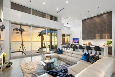 Large open concept concrete floor and gray floor living room photo in Tampa with white walls, a ribbon fireplace and a wall-mounted tv