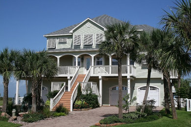 Inspiration for a large coastal green three-story wood house exterior remodel in Houston with a hip roof and a shingle roof