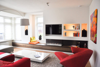 Example of a mid-sized trendy enclosed dark wood floor living room design in Amsterdam with a music area, white walls, a media wall and a ribbon fireplace