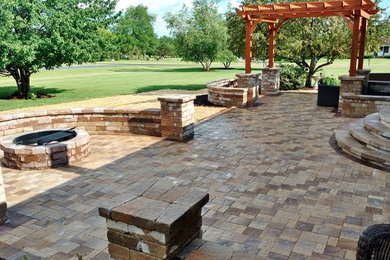 Photo of a contemporary backyard patio in Other with a fire feature, brick pavers and a pergola.