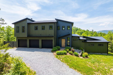 Minimalist green two-story concrete fiberboard and board and batten house exterior photo in Charlotte with a shed roof, a metal roof and a black roof