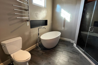 Large trendy ceramic tile and gray floor bathroom photo in Philadelphia with beige walls, a hinged shower door, a niche and a freestanding vanity