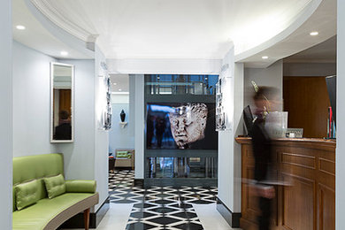 This is an example of a large contemporary foyer in Rome with blue walls and marble flooring.