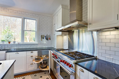 Inspiration for an arts and crafts galley eat-in kitchen in New York with a farmhouse sink, shaker cabinets, white cabinets, white splashback, subway tile splashback, stainless steel appliances and marble benchtops.