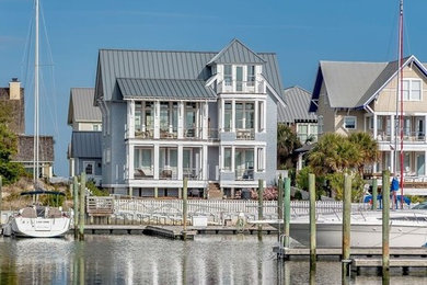 Large coastal gray three-story wood exterior home idea in Other with a metal roof