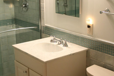 This is an example of a mid-sized modern 3/4 bathroom in Chicago with white cabinets, an alcove shower, blue tile, white tile and white walls.