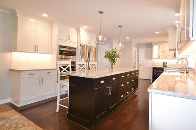 Inspiration for a large transitional u-shaped eat-in kitchen in Philadelphia with an undermount sink, flat-panel cabinets, white cabinets, granite benchtops, white splashback, subway tile splashback, stainless steel appliances, dark hardwood floors and with island.