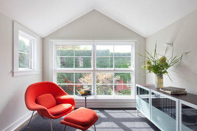 This is an example of a transitional family room in New York with a library and grey walls.