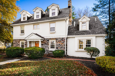 Large elegant white three-story stucco gable roof photo in Philadelphia