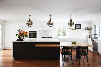This is an example of a large modern l-shaped eat-in kitchen in Sydney with an undermount sink, flat-panel cabinets, white splashback, medium hardwood floors, with island, brown floor and white benchtop.
