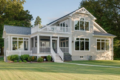 Inspiration for a large timeless beige two-story wood house exterior remodel in San Francisco with a clipped gable roof and a shingle roof