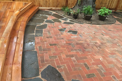 Photo of a mid-sized arts and crafts backyard patio in New York with brick pavers and no cover.