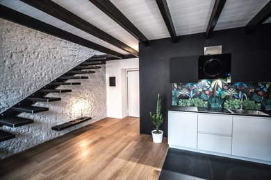 Ispirazione per una piccola cucina industriale con lavello da incasso, ante lisce, ante bianche, top in laminato, paraspruzzi multicolore, paraspruzzi con piastrelle in ceramica, elettrodomestici in acciaio inossidabile, pavimento con piastrelle in ceramica, pavimento nero e top nero
