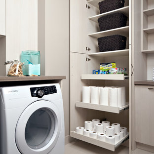 Diseño de lavadero multiusos, contemporáneo, grande, con armarios con paneles lisos, puertas de armario de madera clara, encimera de laminado, paredes beige y lavadora y secadora juntas